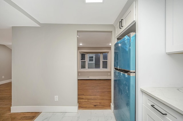 12 Barberry Ln, Middle Island, NY 11953 - kitchen with freestanding refrigerator, baseboards, light stone counters, white cabinetry, and marble finish flooring