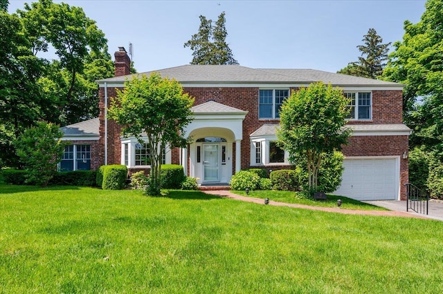 14 Pond Park Rd, Great Neck, NY 11023 - view of front of house featuring an attached garage, a front lawn, a chimney, and concrete driveway