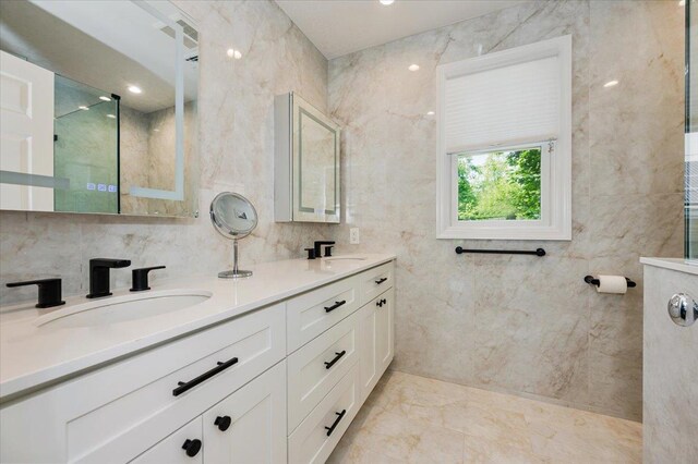 14 Pond Park Rd, Great Neck, NY 11023 - full bathroom with double vanity, a walk in shower, marble tiled flooring, and tile walls