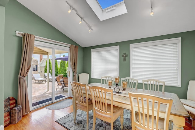 224 Biltmore Blvd, Massapequa, NY 11758 - dining room featuring rail lighting, vaulted ceiling, a skylight, and light wood finished floors