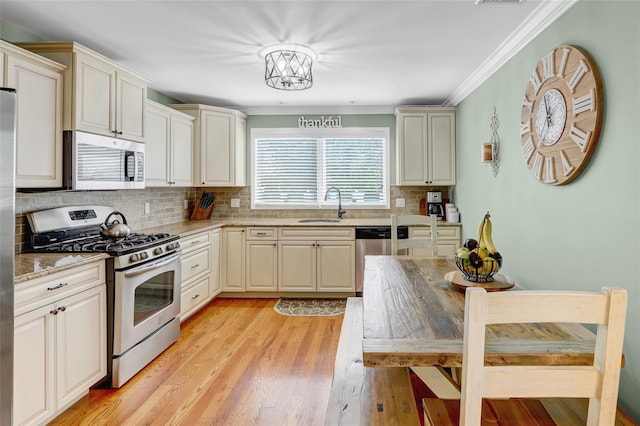 224 Biltmore Blvd, Massapequa, NY 11758 - kitchen featuring appliances with stainless steel finishes, a sink, decorative backsplash, light wood-type flooring, and crown molding