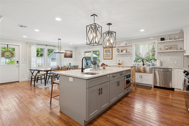 206 Brooksite Dr, Smithtown, NY 11787 - kitchen with stainless steel appliances, open shelves, gray cabinets, a sink, and ornamental molding