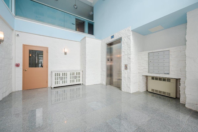 661 W Broadway Unit 203, Long Beach, NY 11561 - unfurnished living room featuring a high ceiling, elevator, radiator, and granite tiled floors