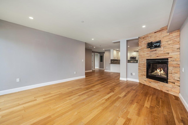 661 W Broadway Unit 203, Long Beach, NY 11561 - unfurnished living room featuring light wood-style flooring, a fireplace, baseboards, and recessed lighting