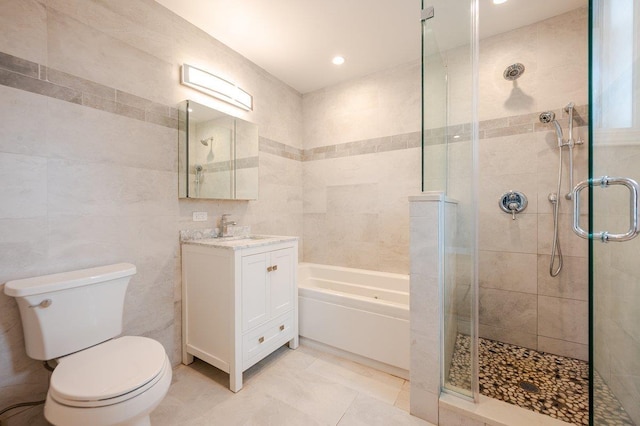 661 W Broadway Unit 203, Long Beach, NY 11561 - bathroom with toilet, a garden tub, a stall shower, vanity, and tile walls