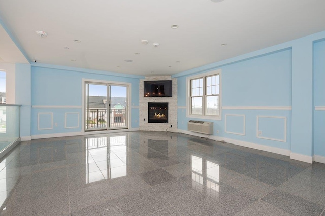 661 W Broadway Unit 203, Long Beach, NY 11561 - unfurnished living room featuring granite tiled floors, a wall mounted AC, and baseboards