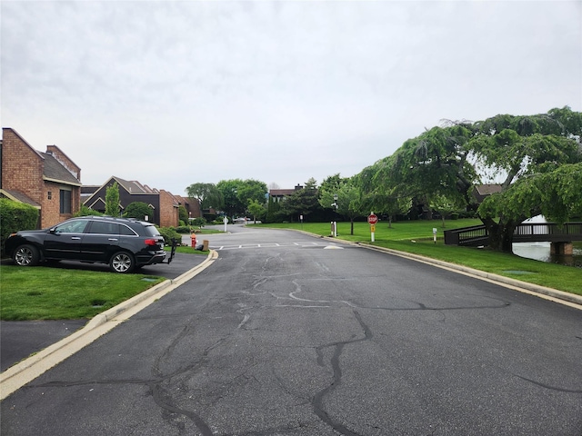 166 Southgate Cir, Massapequa Park, NY 11762 - view of asphalt street featuring curbs, a residential view, and traffic signs
