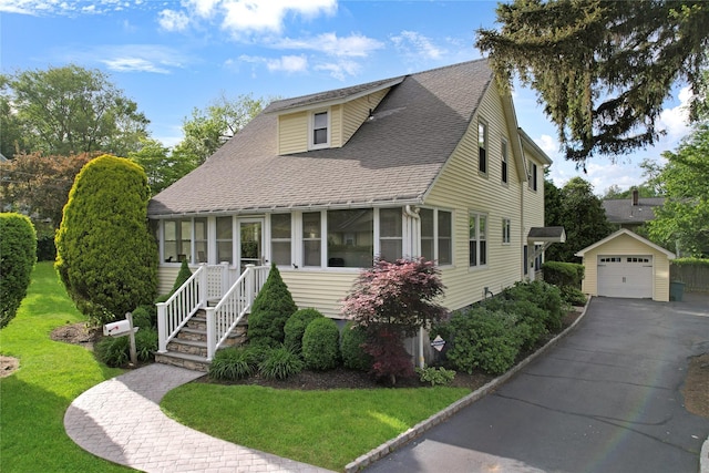 26 Van Nostrand Pl, Nanuet, NY 10954 - view of front of home with an outbuilding, a detached garage, a shingled roof, a front yard, and driveway