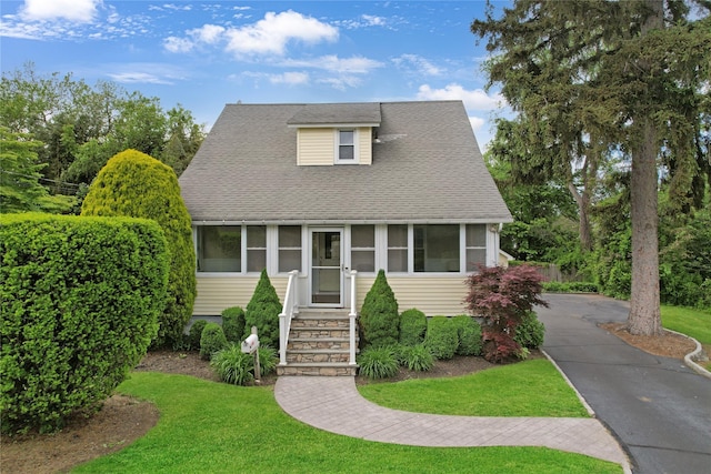 26 Van Nostrand Pl, Nanuet, NY 10954 - view of front facade with a sunroom, a front lawn, and a shingled roof