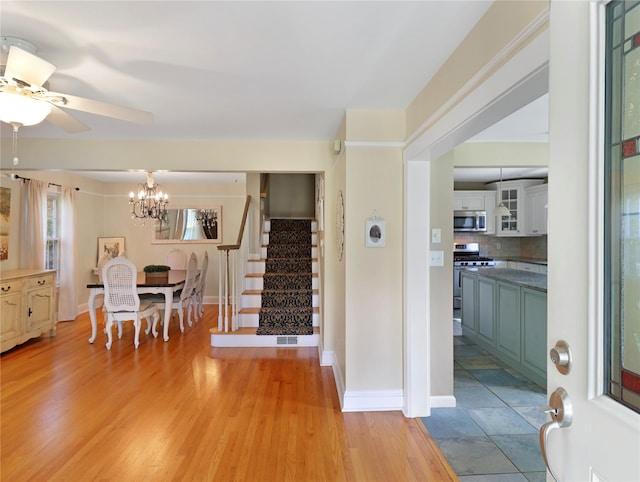26 Van Nostrand Pl, Nanuet, NY 10954 - entrance foyer with stairs, a chandelier, a ceiling fan, light wood-style floors, and baseboards