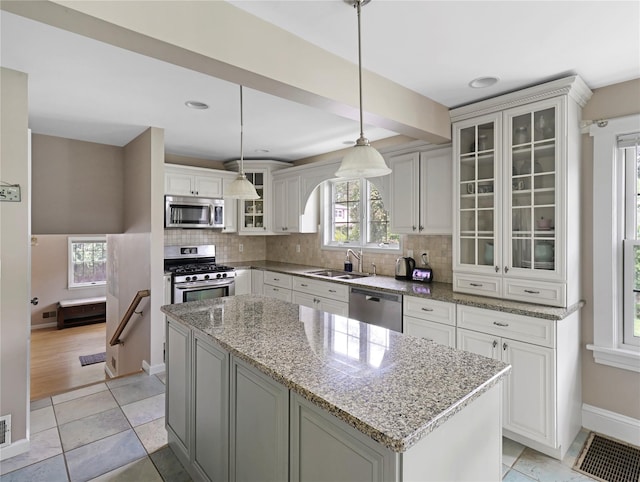 26 Van Nostrand Pl, Nanuet, NY 10954 - kitchen with appliances with stainless steel finishes, a sink, a kitchen island, baseboards, and backsplash