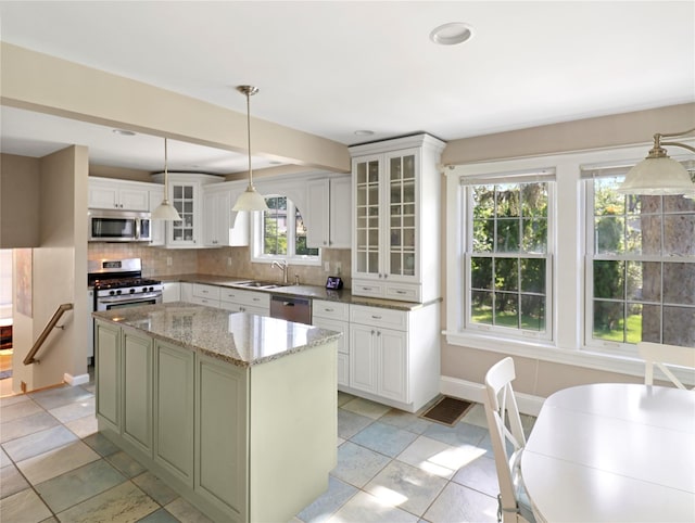 26 Van Nostrand Pl, Nanuet, NY 10954 - kitchen with stainless steel appliances, a sink, backsplash, a kitchen island, and light stone countertops
