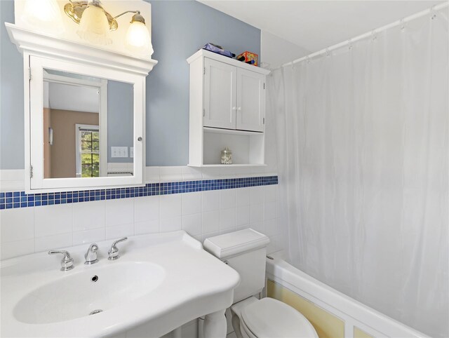 26 Van Nostrand Pl, Nanuet, NY 10954 - bathroom with tile walls, a sink, toilet, and shower / bath combo with shower curtain
