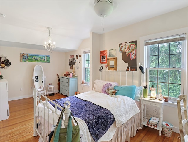 26 Van Nostrand Pl, Nanuet, NY 10954 - bedroom with multiple windows, light wood finished floors, vaulted ceiling, a chandelier, and baseboards