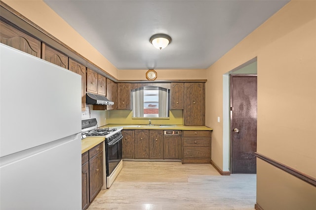 160 Laconia Ave, Staten Island, NY 10305 - kitchen with freestanding refrigerator, range with gas stovetop, under cabinet range hood, light countertops, and a sink