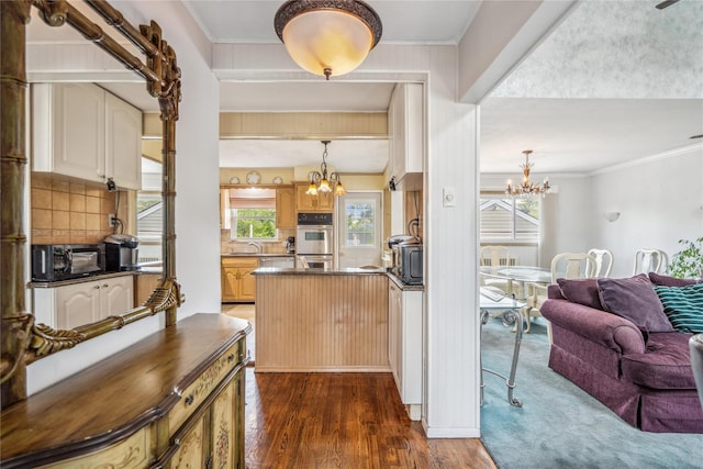 697 Byron Ave, Franklin Square, NY 11010 - kitchen with a chandelier, dark wood finished floors, dark countertops, stainless steel double oven, and tasteful backsplash