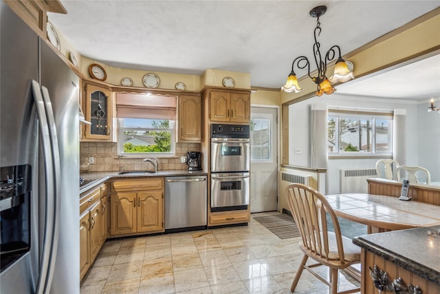 697 Byron Ave, Franklin Square, NY 11010 - kitchen with stainless steel appliances, radiator, a chandelier, backsplash, and dark countertops