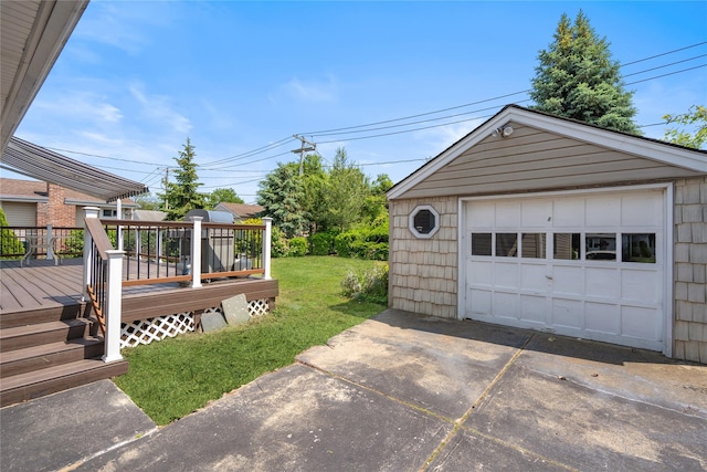 697 Byron Ave, Franklin Square, NY 11010 - view of grassy yard featuring a detached garage, a deck, concrete driveway, and an outbuilding