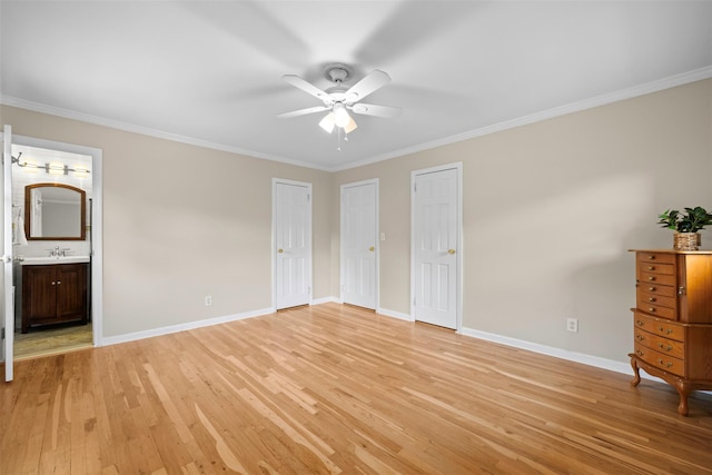 613 Gary Pl, Westbury, NY 11590 - unfurnished bedroom featuring crown molding, light wood-type flooring, baseboards, two closets, and ensuite bath