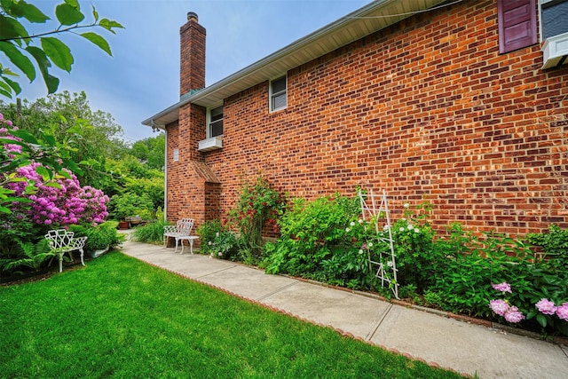 613 Gary Pl, Westbury, NY 11590 - view of property exterior with a chimney, brick siding, and a lawn