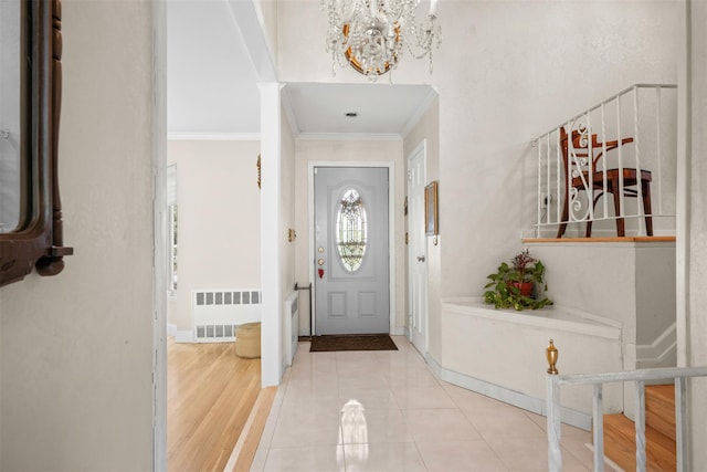 613 Gary Pl, Westbury, NY 11590 - foyer entrance with radiator, a chandelier, crown molding, and baseboards