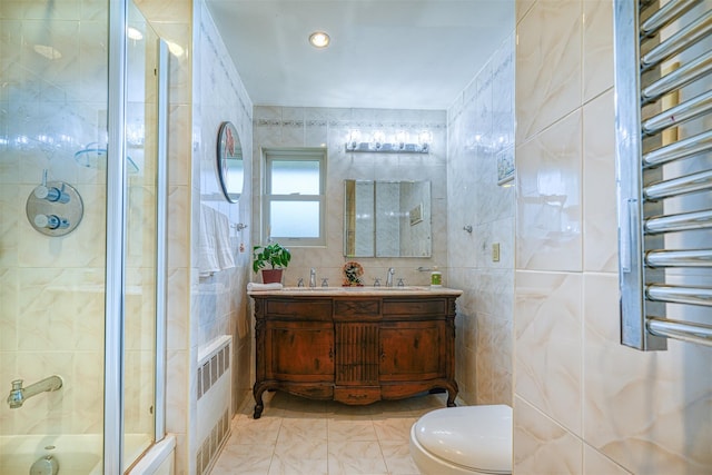 613 Gary Pl, Westbury, NY 11590 - bathroom featuring radiator heating unit, tile walls, a towel warming rack, a tile shower, and toilet