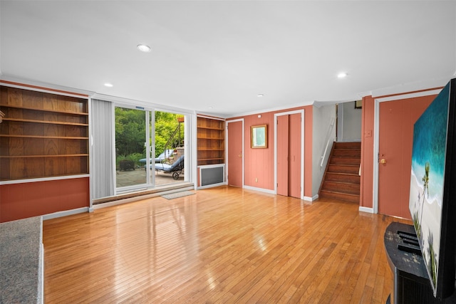 613 Gary Pl, Westbury, NY 11590 - unfurnished living room featuring stairs, wood-type flooring, built in shelves, baseboards, and recessed lighting