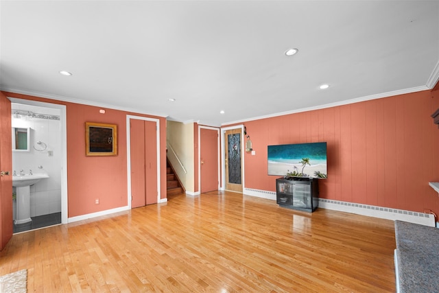 613 Gary Pl, Westbury, NY 11590 - unfurnished living room featuring stairs, a baseboard heating unit, ornamental molding, light wood-style floors, and baseboards