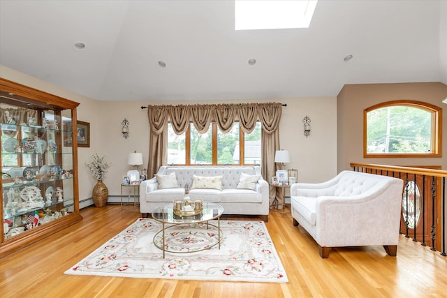314 Oakview Ave, Oceanside, NY 11572 - living room featuring vaulted ceiling, light wood finished floors, a baseboard radiator, and a skylight