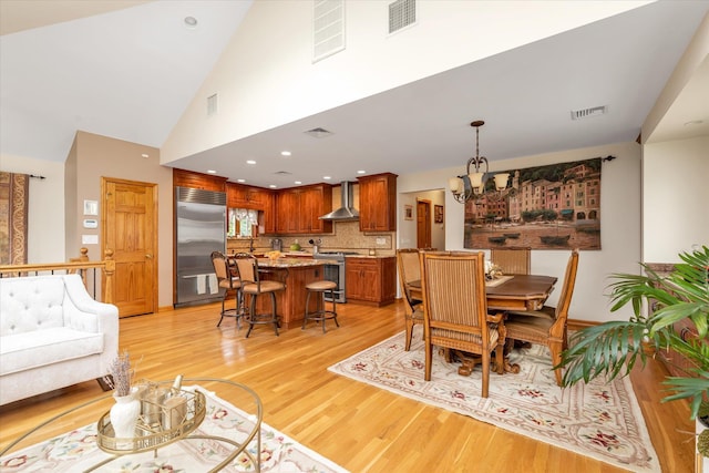 314 Oakview Ave, Oceanside, NY 11572 - dining space featuring a chandelier, light wood finished floors, and a high ceiling