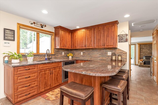 314 Oakview Ave, Oceanside, NY 11572 - kitchen featuring a sink, a kitchen breakfast bar, tasteful backsplash, brown cabinetry, and recessed lighting