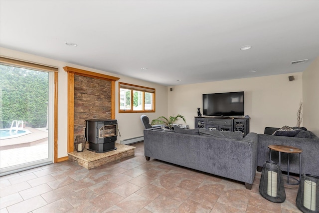 314 Oakview Ave, Oceanside, NY 11572 - living area with a wood stove, a baseboard heating unit, recessed lighting, light stone finish floors, and baseboards
