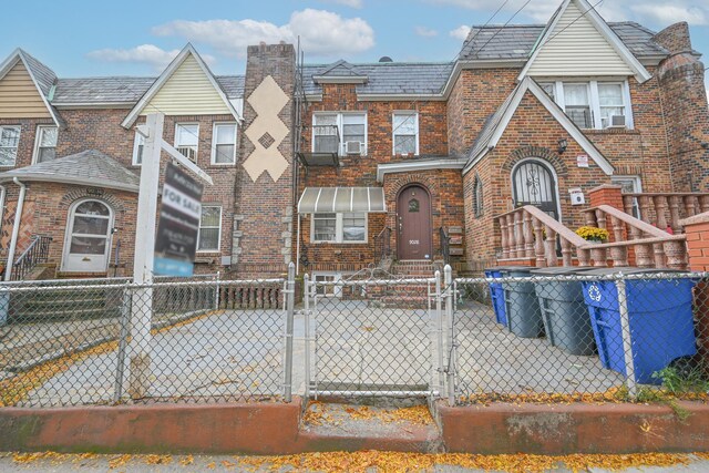 90-28 Pitkin Ave, Ozone Park, NY 11417 - view of front of property with a gate, brick siding, a fenced front yard, and a high end roof