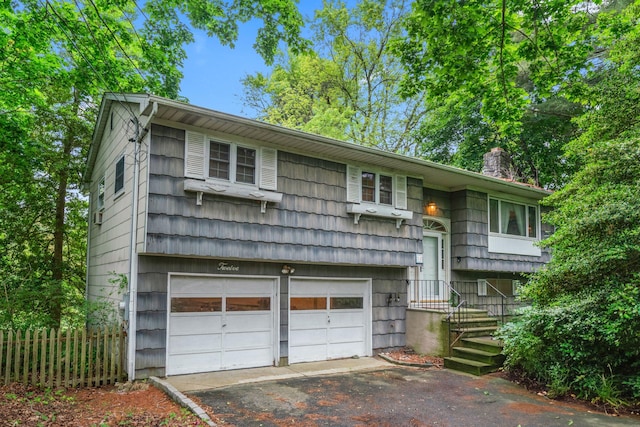 12 Ursular Ct, Smithtown, NY 11787 - raised ranch featuring a garage, asphalt driveway, and a chimney