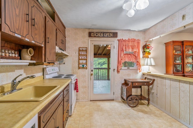 12 Ursular Ct, Smithtown, NY 11787 - kitchen with white range with electric cooktop, wallpapered walls, light countertops, brown cabinetry, and open shelves
