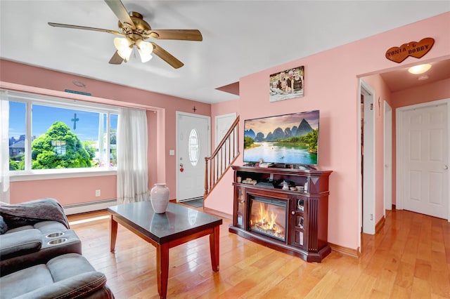 674 Shore Rd, Lindenhurst, NY 11757 - living area with baseboard heating, light wood finished floors, a ceiling fan, stairs, and baseboards