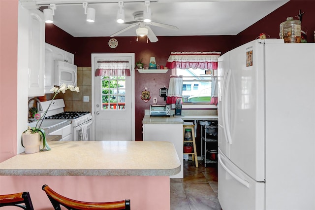 674 Shore Rd, Lindenhurst, NY 11757 - kitchen with white appliances, a ceiling fan, a peninsula, white cabinetry, and light countertops