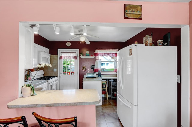 674 Shore Rd, Lindenhurst, NY 11757 - kitchen featuring white appliances, light countertops, a ceiling fan, white cabinetry, and a peninsula