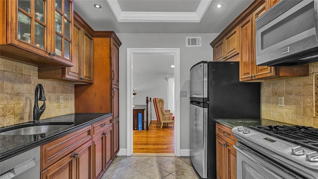 3123 Lydia Ln, Bellmore, NY 11710 - kitchen featuring stainless steel appliances, a tray ceiling, dark stone counters, glass insert cabinets, and tasteful backsplash