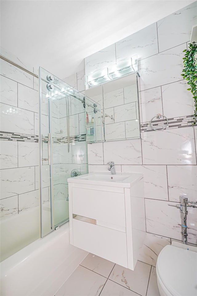 2121 Shore Pkwy Unit 2P, Brooklyn, NY 11214 - full bath with shower / bath combination with glass door, vanity, toilet, marble finish flooring, and tile walls