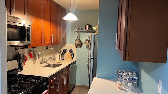 52-40 39th Dr Unit 9J, Woodside, NY 11377 - kitchen featuring appliances with stainless steel finishes, a sink, decorative backsplash, light countertops, and hanging light fixtures