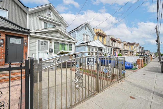 102-34 127th St, Richmond Hill S, NY 11419 - view of front of home with a residential view, a fenced front yard, and a gate