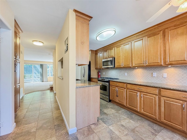 203 Dover Grn, Staten Island, NY 10312 - kitchen featuring appliances with stainless steel finishes, decorative backsplash, baseboards, light stone countertops, and light stone finish floors