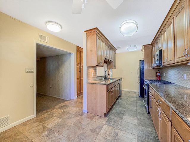 203 Dover Grn, Staten Island, NY 10312 - kitchen featuring stainless steel appliances, baseboards, backsplash, a ceiling fan, and dark stone countertops