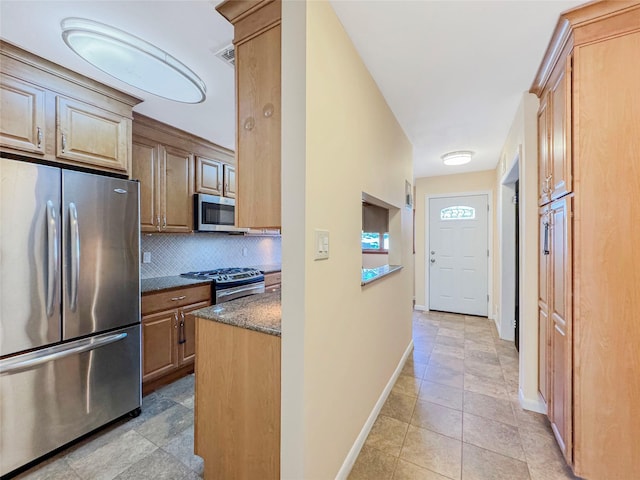 203 Dover Grn, Staten Island, NY 10312 - kitchen with stainless steel appliances, decorative backsplash, baseboards, dark stone countertops, and light tile patterned flooring