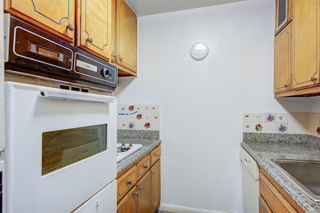 102-30 66th Rd Unit 14D, Forest Hills, NY 11375 - kitchen featuring white appliances, brown cabinetry, a sink, and baseboards