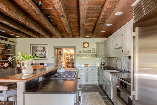 26 Roberson Ave, Pine Bush, NY 12566 - kitchen with appliances with stainless steel finishes, wooden ceiling with exposed beams, a sink, dark countertops, and decorative backsplash