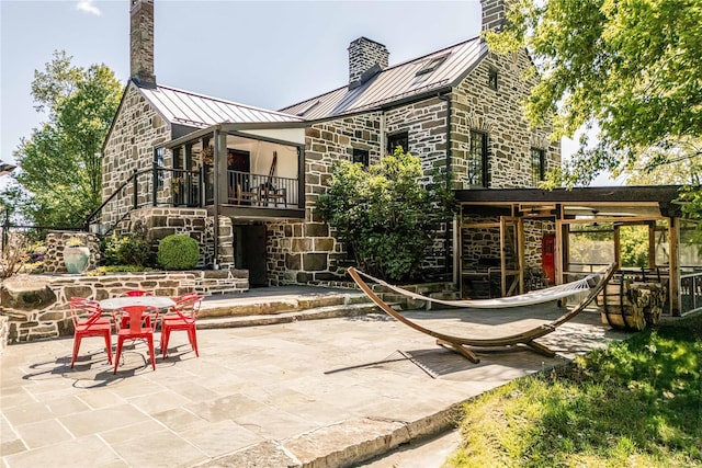 26 Roberson Ave, Pine Bush, NY 12566 - back of house with a standing seam roof, a chimney, and stone siding
