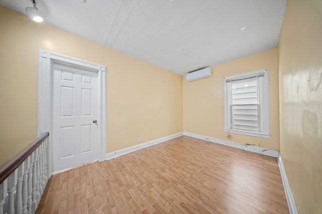 8564 79th St, Woodhaven, NY 11421 - spare room featuring a wall unit AC, wood finished floors, baseboards, and a textured ceiling