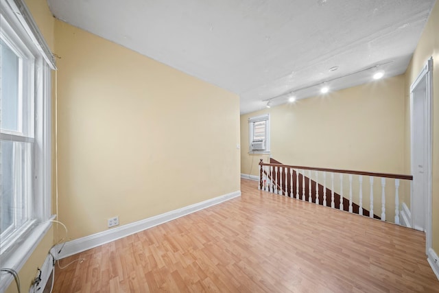 8564 79th St, Woodhaven, NY 11421 - spare room with rail lighting, wood finished floors, baseboards, and cooling unit
